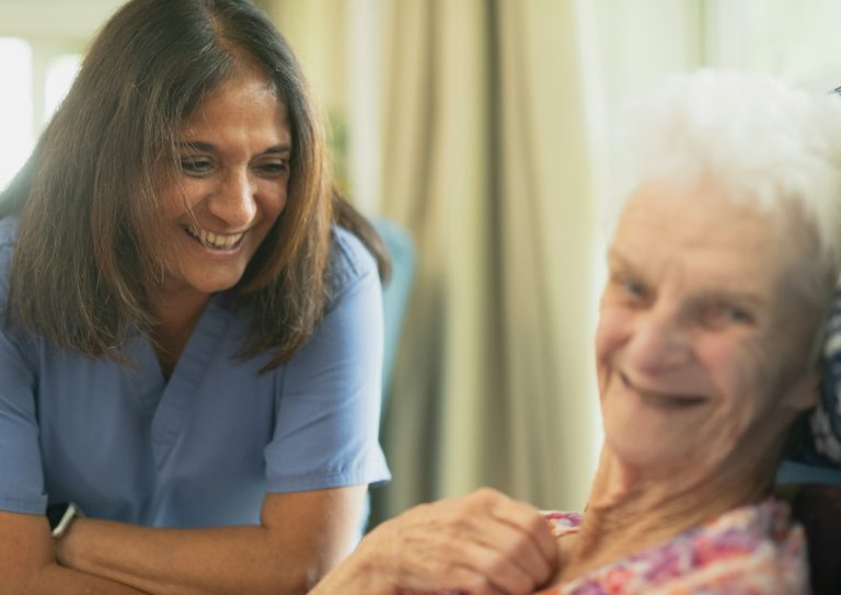Nurse talking with an older woman at home