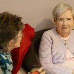 Two older women sitting and talking at home