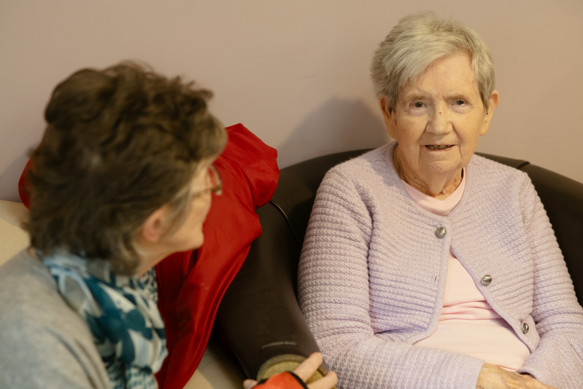 Two older women sitting and talking at home